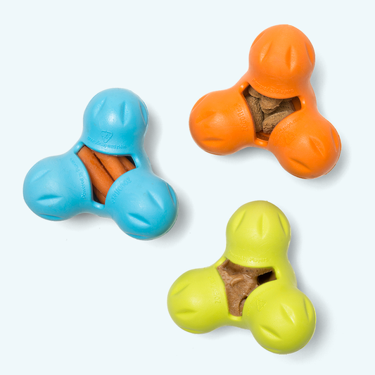 Three colorful dog toys with treat compartments on a white background