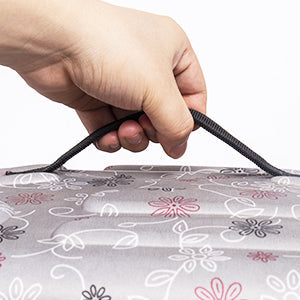 Hand holding a floral-patterned fabric bag with a close-up view.