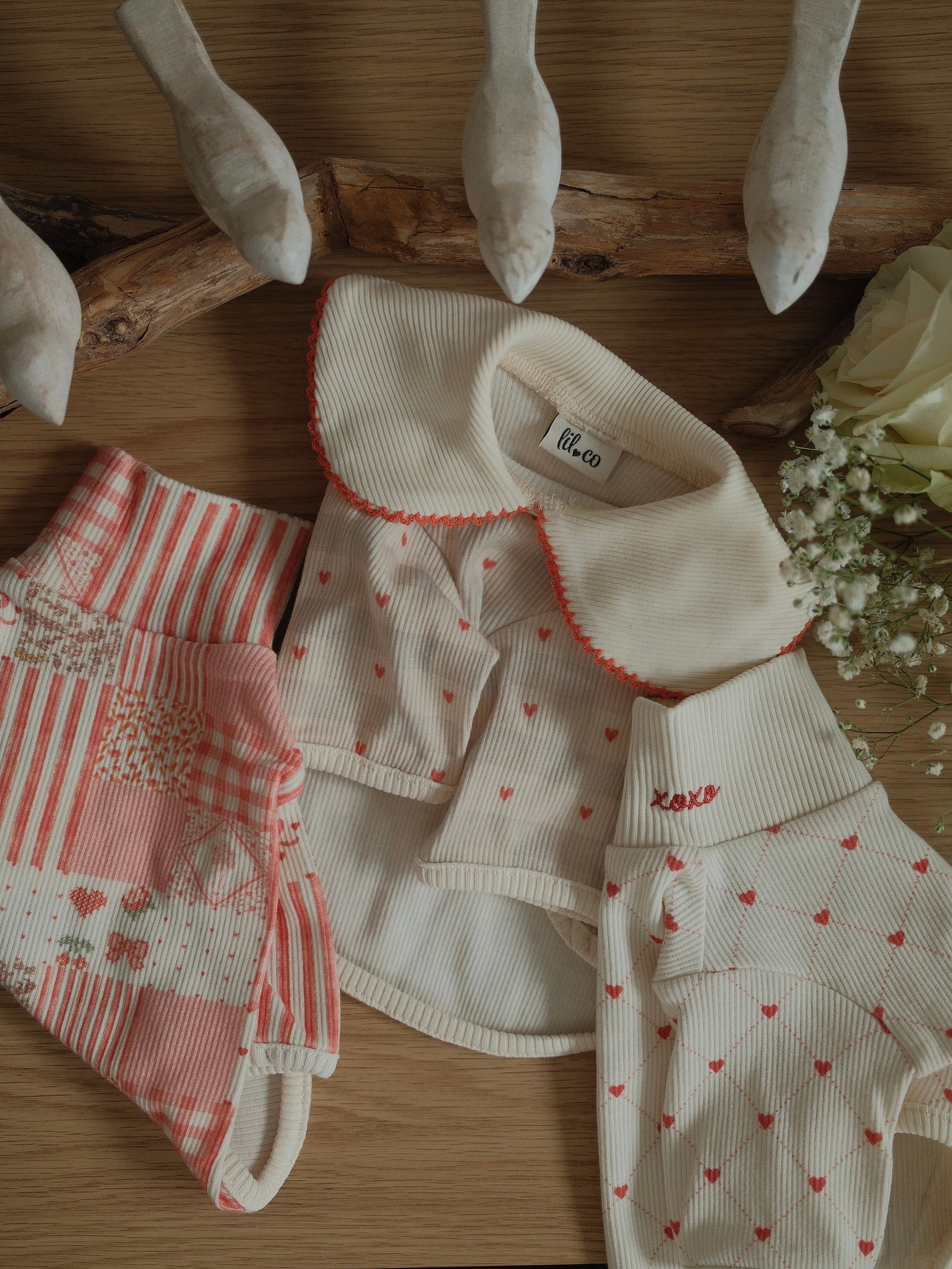 pet clothing set with heart patterns on a wooden surface
