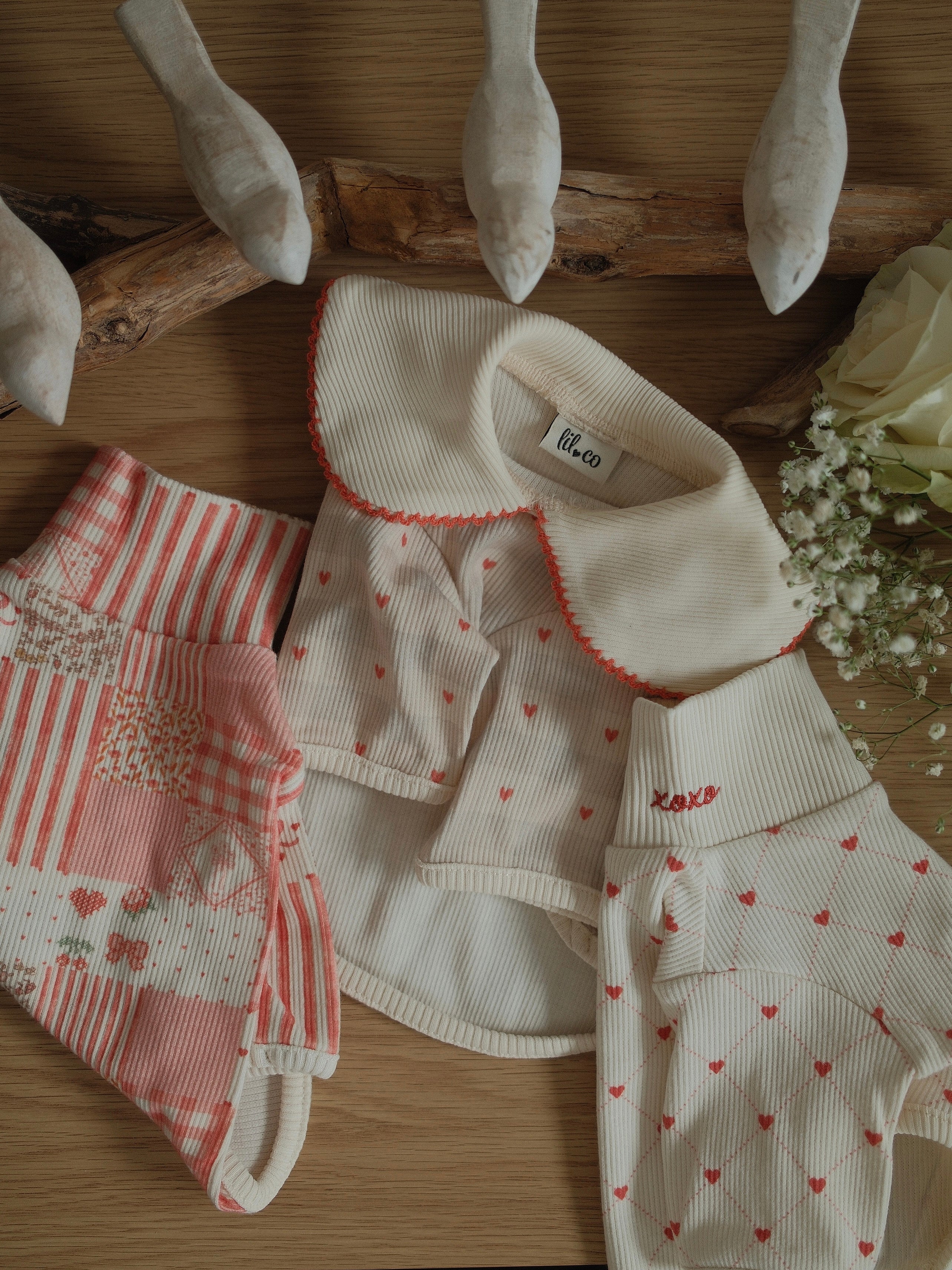 pet clothing set with heart patterns on a wooden surface