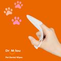Hand holding a white pet dental wipe with pink paw prints on an orange background, featuring the brand 'Dr. Milou'.