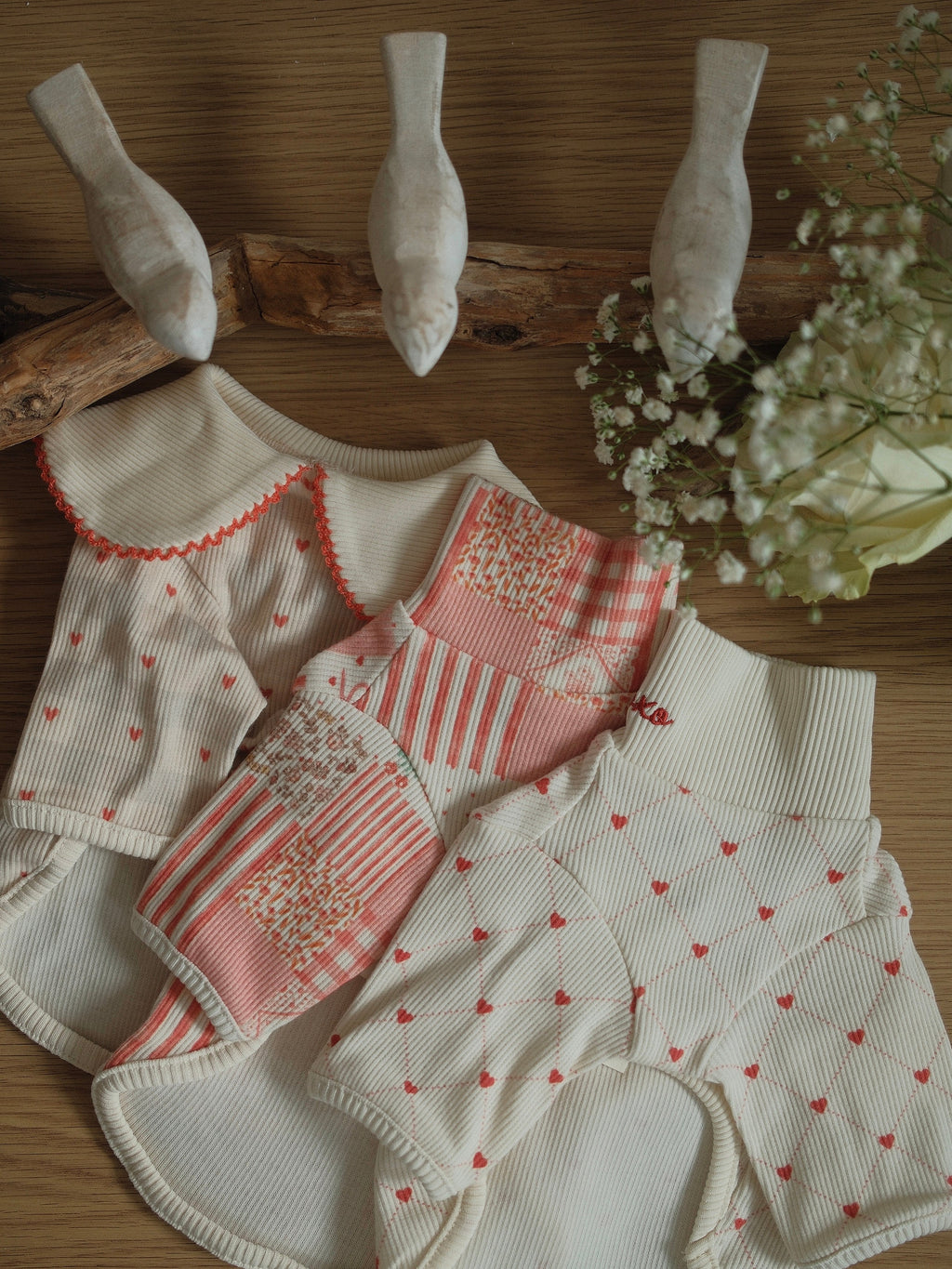 Collection of pet sweater with various patterns on a wooden surface.