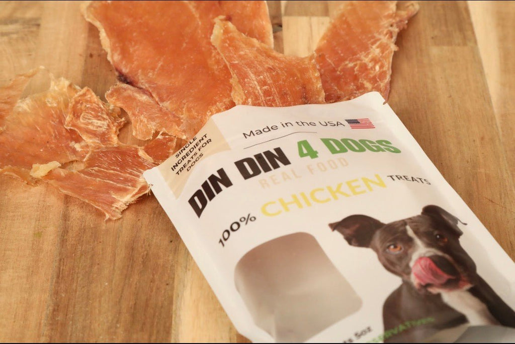DIN DIN 4 DOGS chicken treats packaging on a wooden surface with treats.