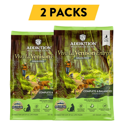 Two packs of Addiction Viva La Venison Entrée grain-free cat food with a forest background.