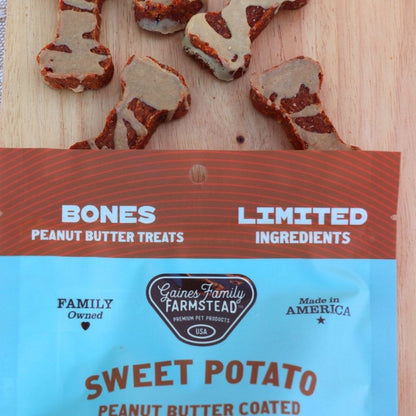 Gaines Family Farmstead sweet potato peanut butter coated treats on a wooden surface with packaging in the foreground.