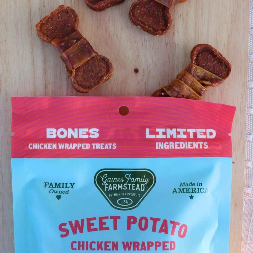 Gaines Family Farmstead sweet potato chicken wrapped treats on a wooden surface with packaging in the foreground.
