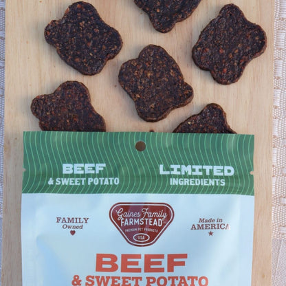Beef and sweet potato treats on a wooden board with a Gaines Family Farmstead package.