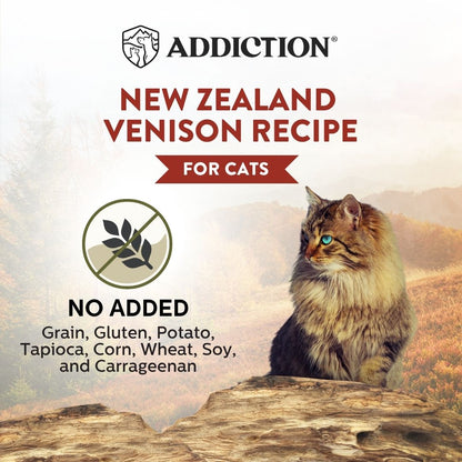 Cat sitting on a rock with 'Addiction' cat food packaging featuring New Zealand Venison recipe.