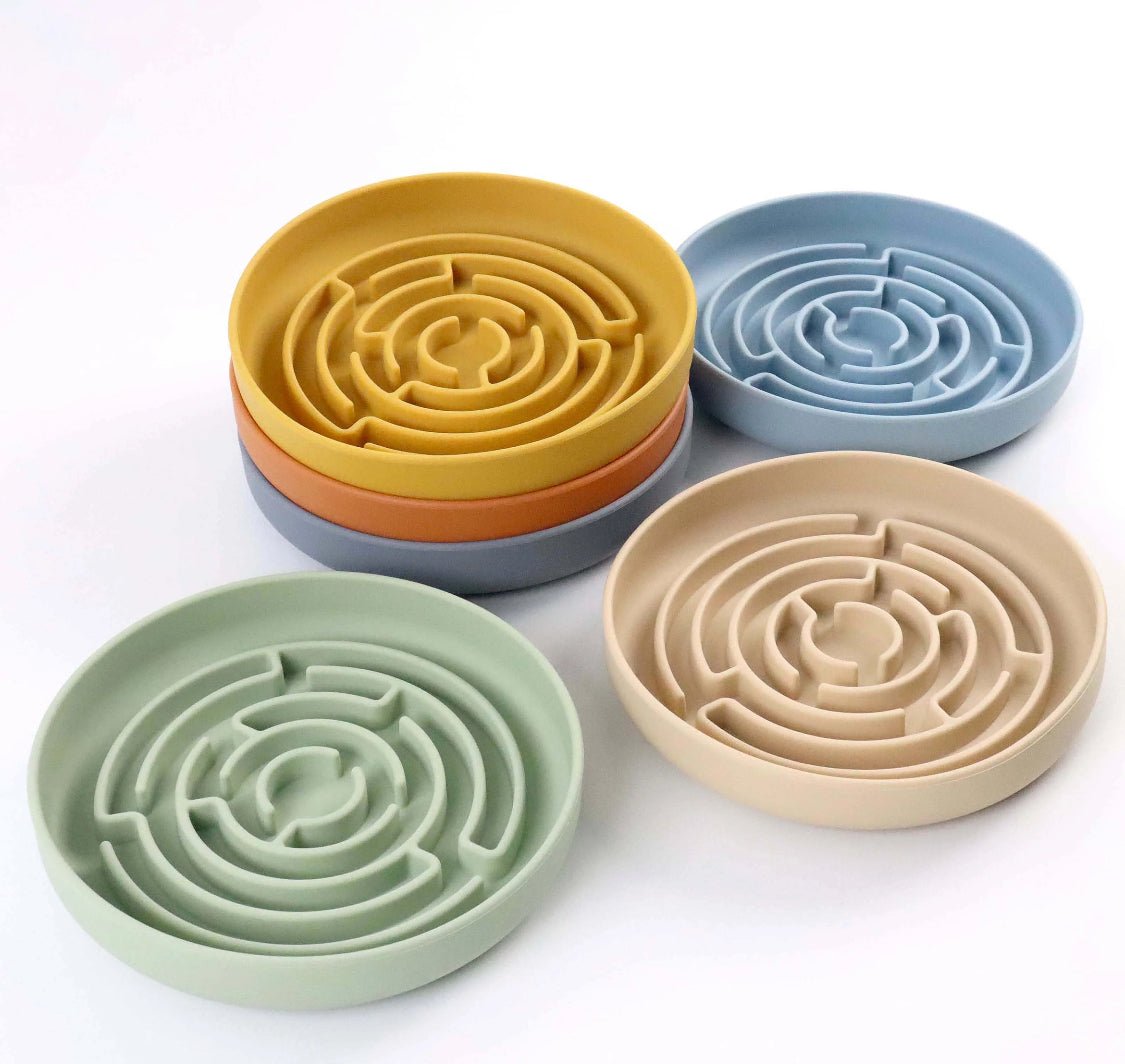 Set of four colorful silicone maze bowls on a white background