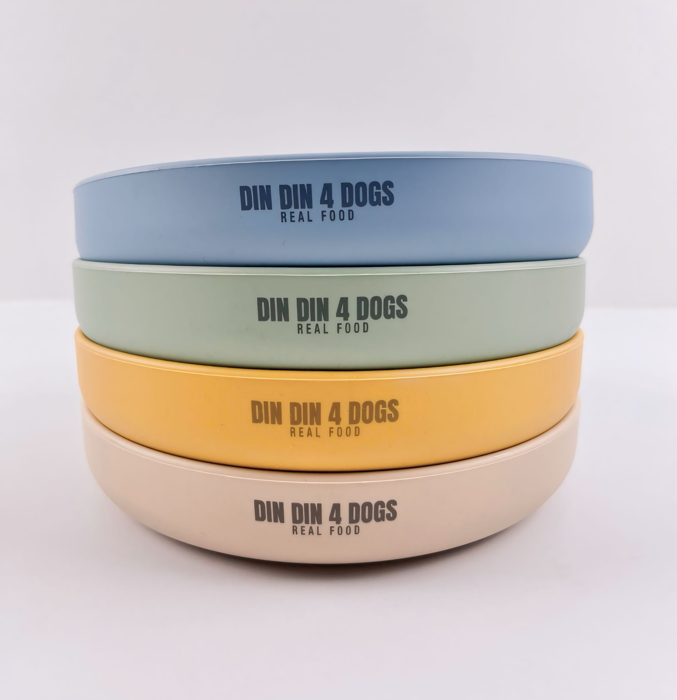 Stack of four dog bowls in different colors with 'DIN DIN 4 DOGS' branding on a light gray background.