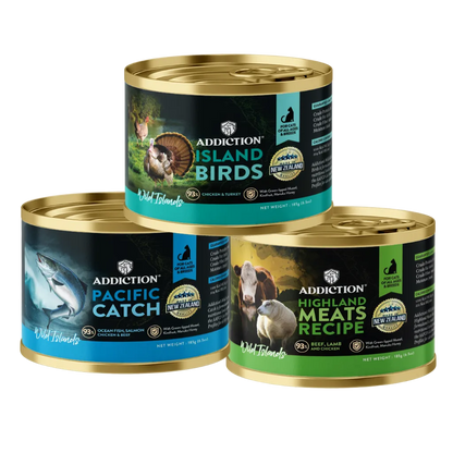 Three cans of Addiction pet food with different labels on a white background