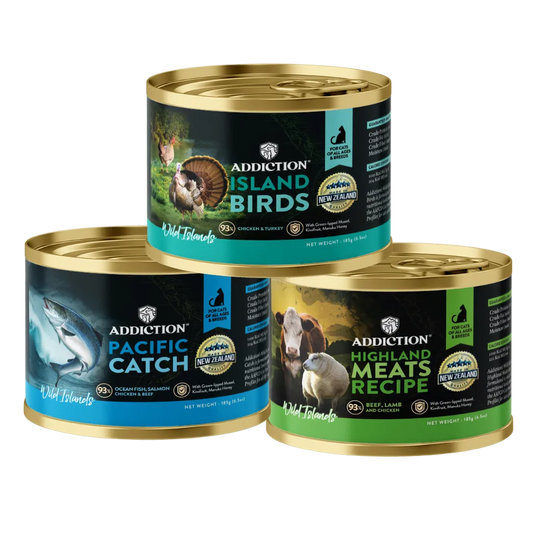 Three cans of Addiction pet food with different labels on a white background