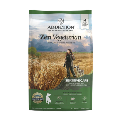 A bag of Addiction Zen Vegetarian Sensitive Care dog food, featuring a scenic image of a woman walking her dog through a wheat field with mountains in the background, set against a plain white backdrop.