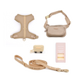Collection of beige pet accessories including a harness, leash, and bag on a white background.