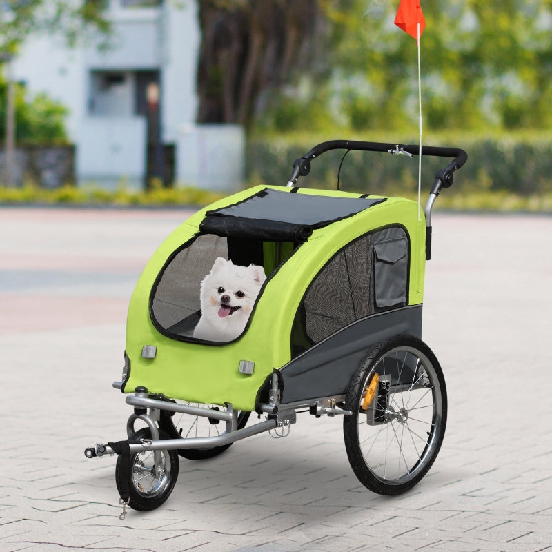 Green and black pet stroller with a white dog inside, on a paved path.