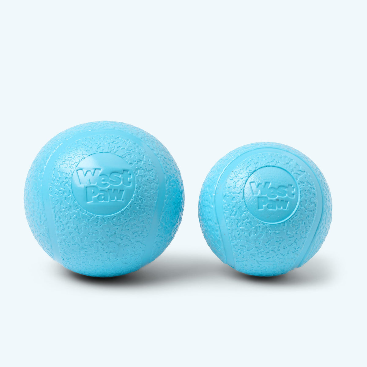 Two blue dog toys with 'West Paw' branding on a white background