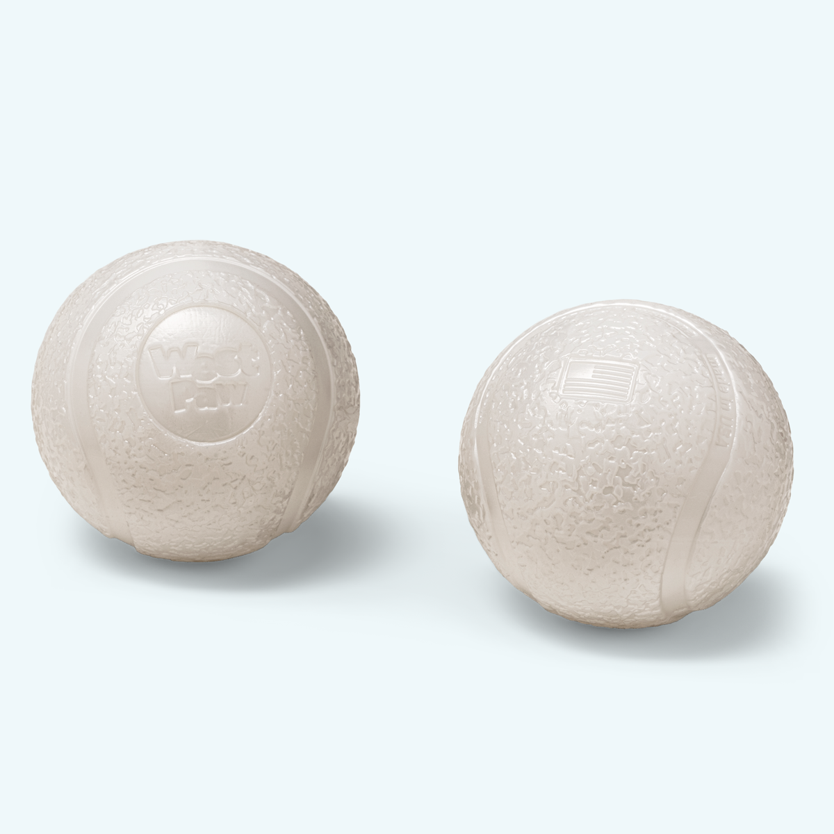 Two white ceramic balls on a light gray background