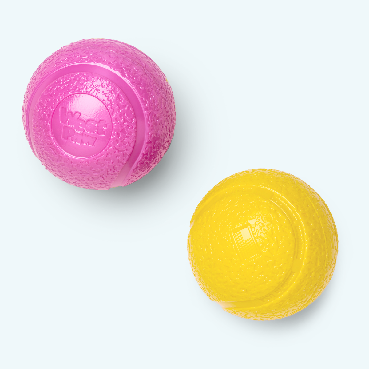 Pink and yellow dog toys on a white background