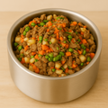 Metal bowl filled with pet food on a beige background