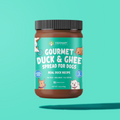 Jar of Gourmet Duck & Ghee Spread for Dogs on a teal background