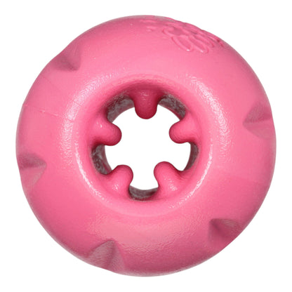 Pink rubber dog toy with a central hole on a white background