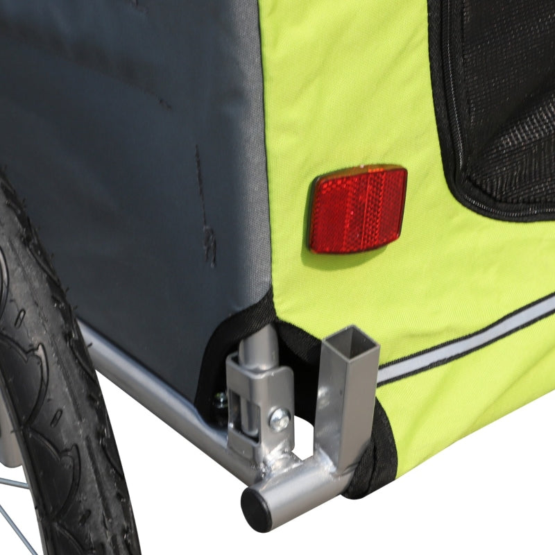 Close-up of a bicycle trailer with a red reflector and black and yellow design.