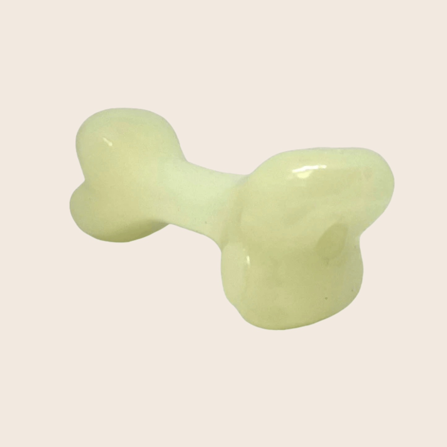 Light green bone-shaped object on a beige background