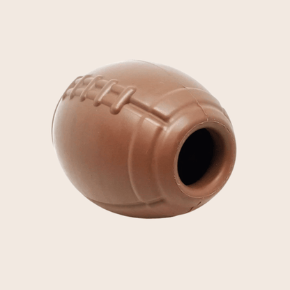 Brown dog toy shaped like a football on a beige background