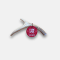 Pink round tag with text on a deer antler against a white background