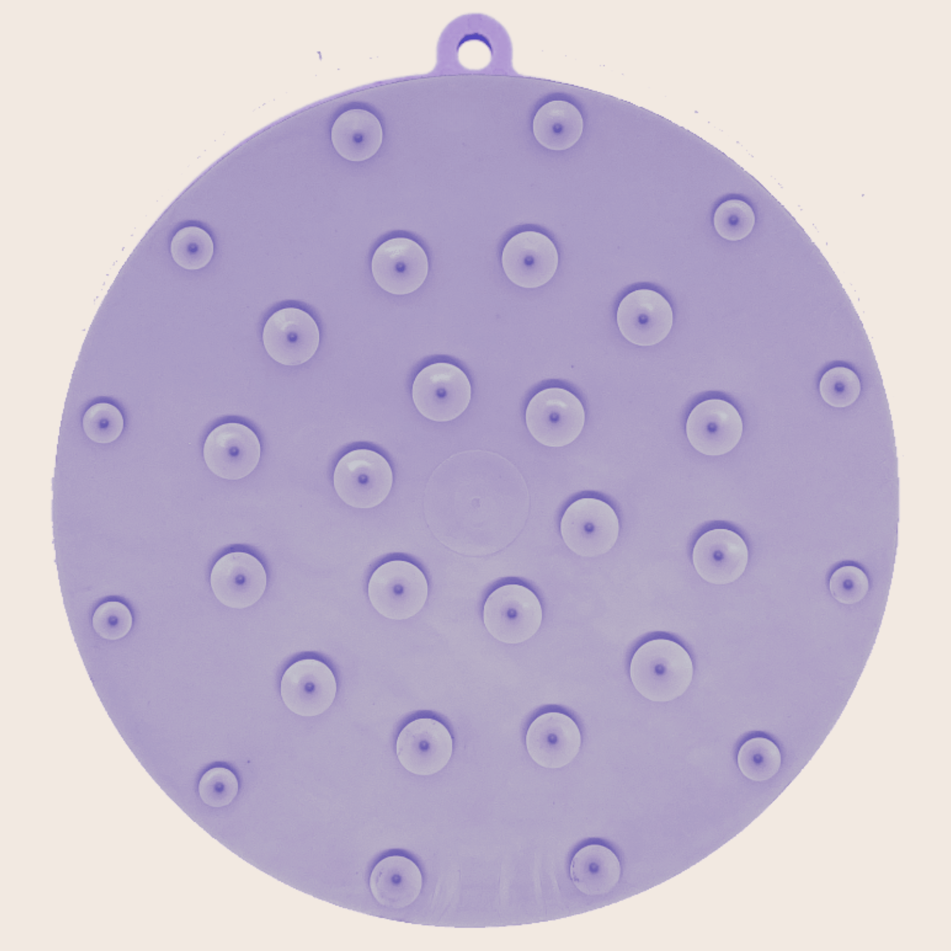 Purple silicone mat with suction cups on a beige background