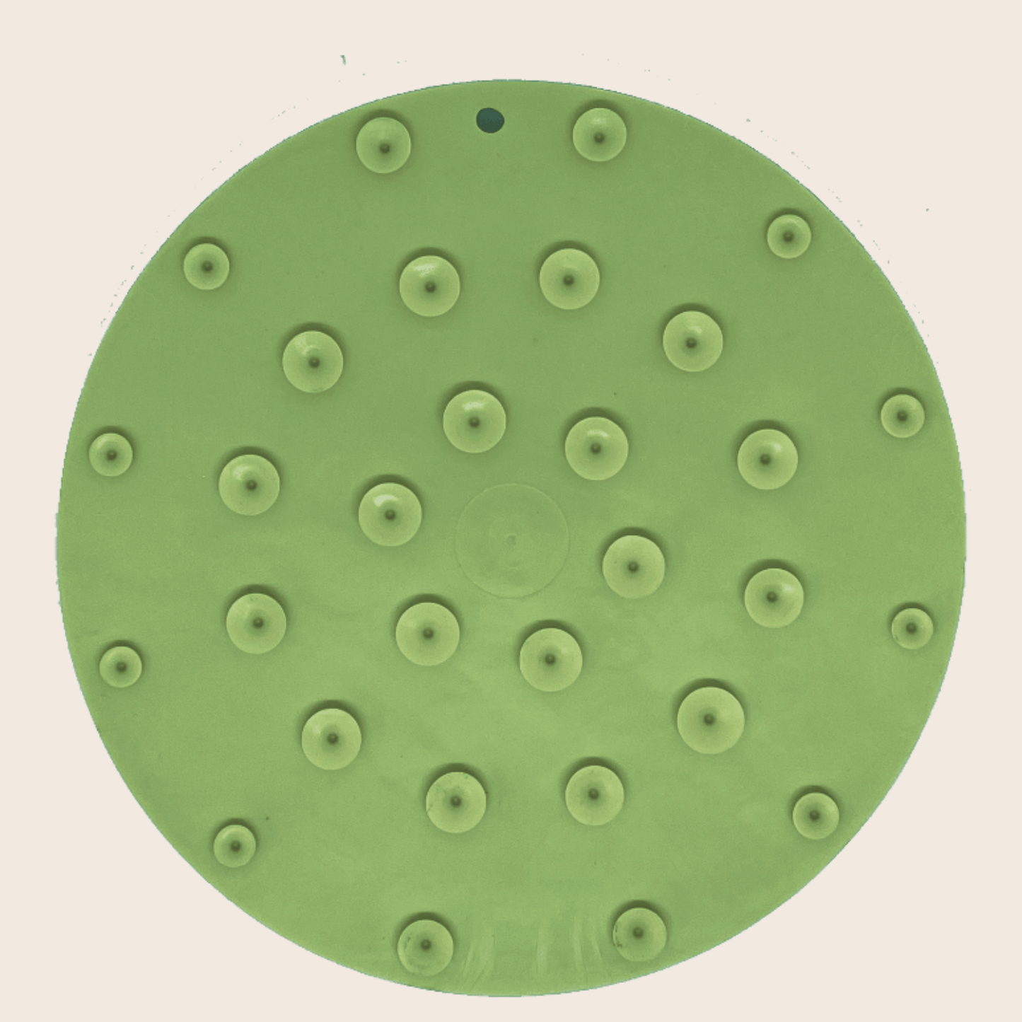 Green sanding disc with multiple holes on a beige background