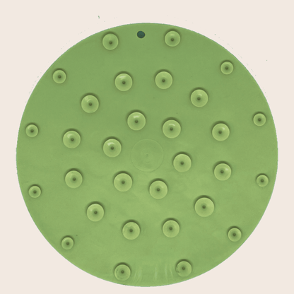 Green sanding disc with multiple holes on a beige background
