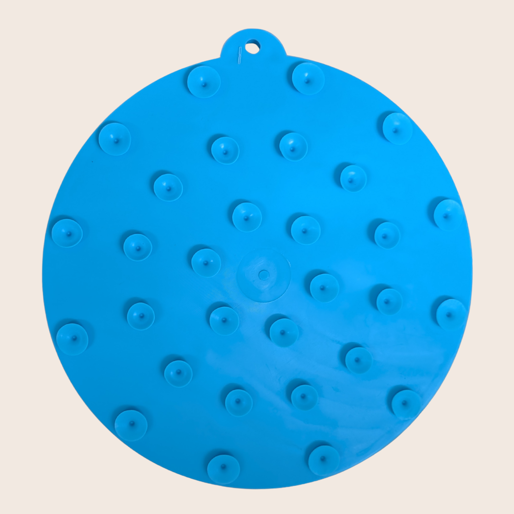 Blue silicone mat with raised circular nodes on a beige background