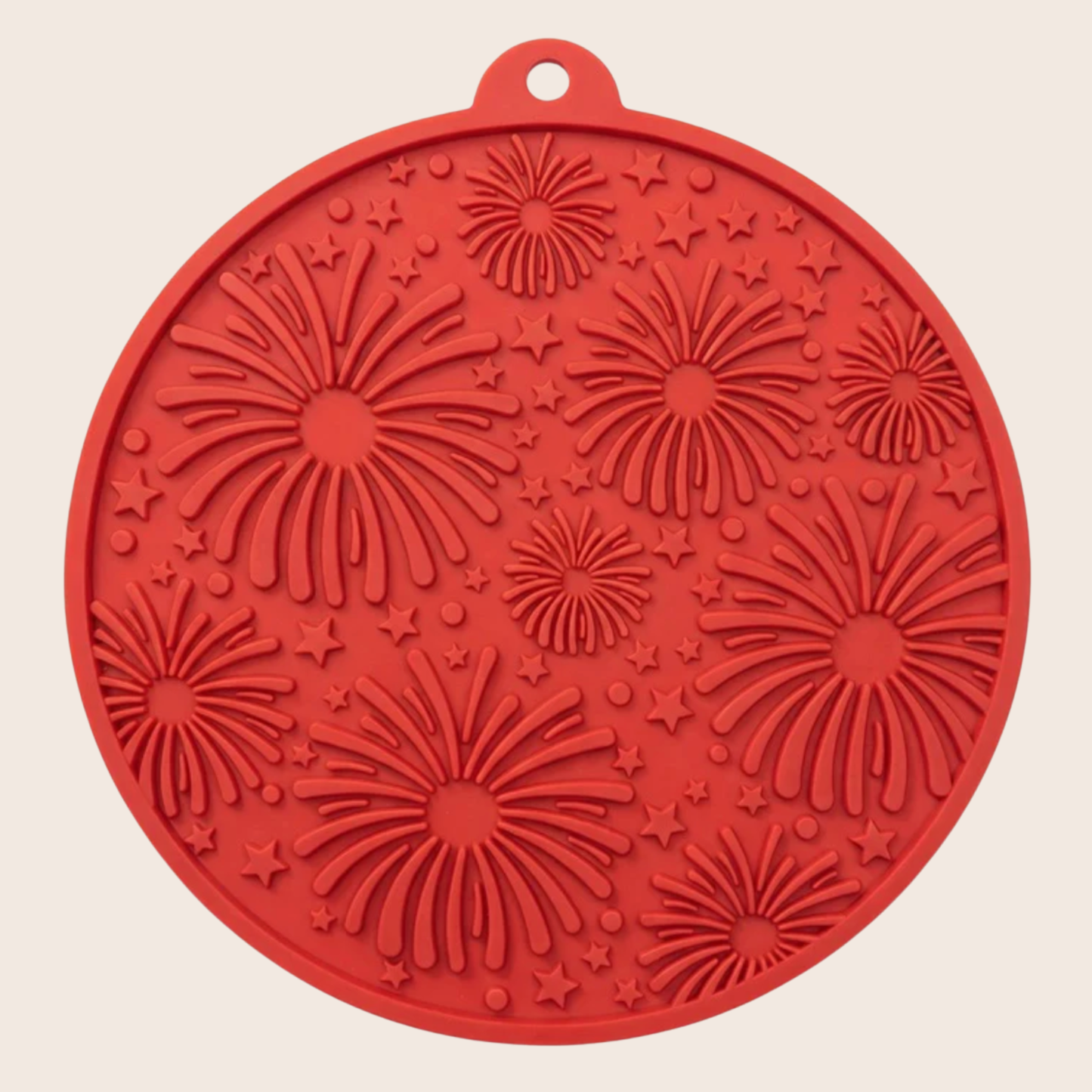 Red silicone mat with firework pattern on a beige background