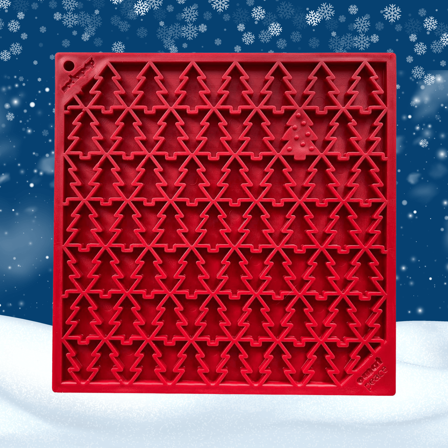 Red silicone mold with Christmas tree pattern on a snowy background