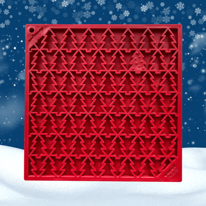 Red silicone mold with Christmas tree pattern on a snowy background
