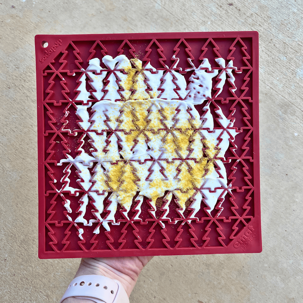 Red silicone mold with geometric pattern filled with white and yellow substance on a beige surface