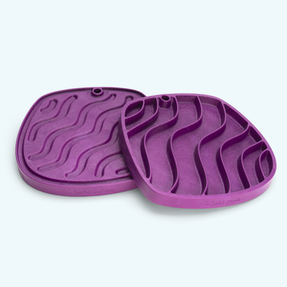 Two purple silicone mats with textured surface on a white background