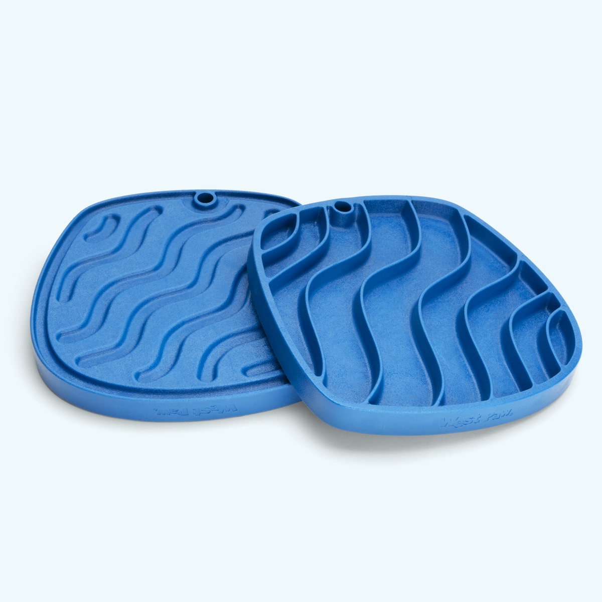 Two blue silicone mats with textured surface on a light gray background