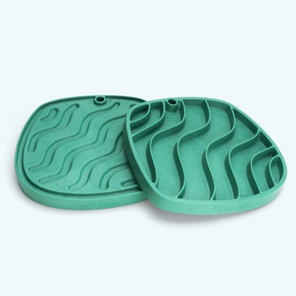 Two green silicone mats with wavy patterns on a white background