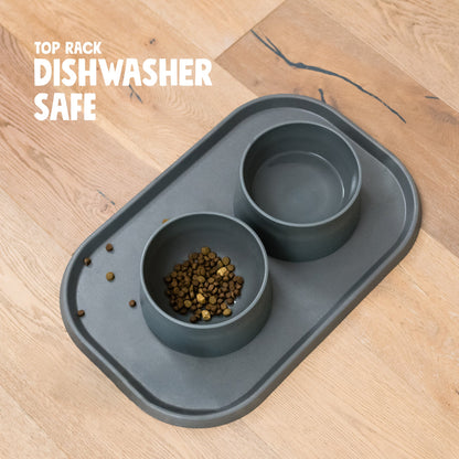 Gray pet feeding station with two bowls on a wooden floor, labeled 'Top Rack Dishwasher Safe'.
