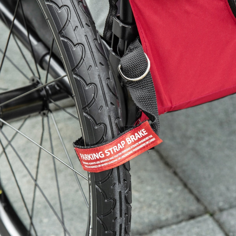 Bicycle wheel with a red 'Parking Strap Brake' label on a pavement background