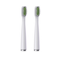 Two white toothbrush heads with green bristles on a white background