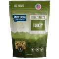 Green package of Montana Dog Food Co. trail snacks with turkey flavor on a white background