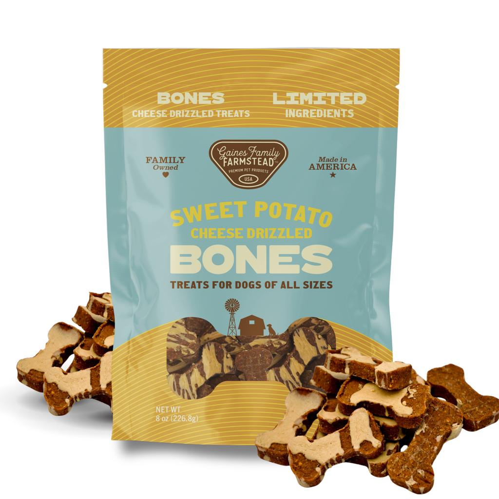 Package of 'Sweet Potato Cheese Drizzled Bones' dog treats with treats displayed in front.