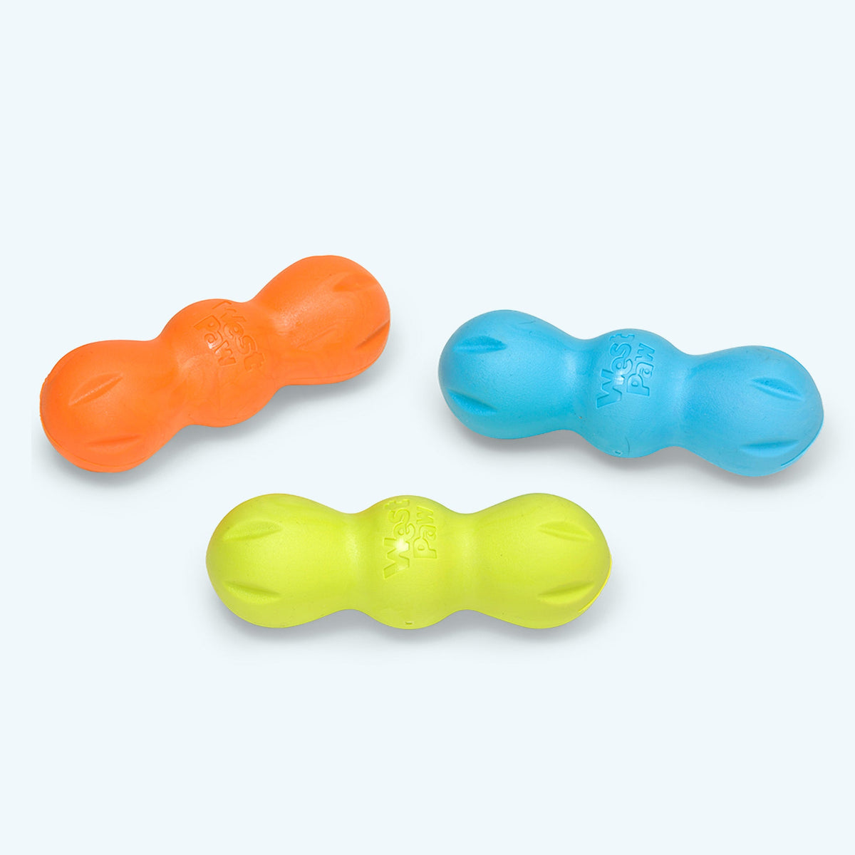 Three colorful dog toys shaped like peanut butter cups on a light gray background