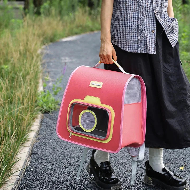 Person holding a pink pet carrier with a checkered shirt and black skirt outdoors.