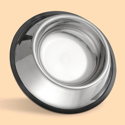 Stainless steel bowl with black rim on a beige background