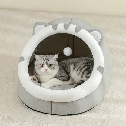 Cat lying inside a gray and white cat-shaped pet bed on a beige carpet.