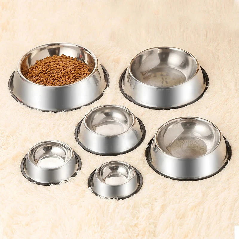 Set of stainless steel pet bowls on a beige background